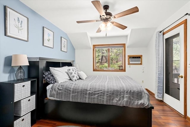 bedroom with access to outside, multiple windows, an AC wall unit, and dark wood-style flooring