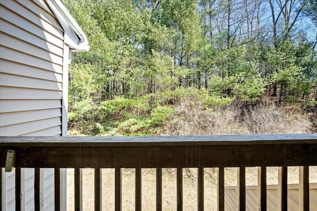 balcony featuring a wooded view