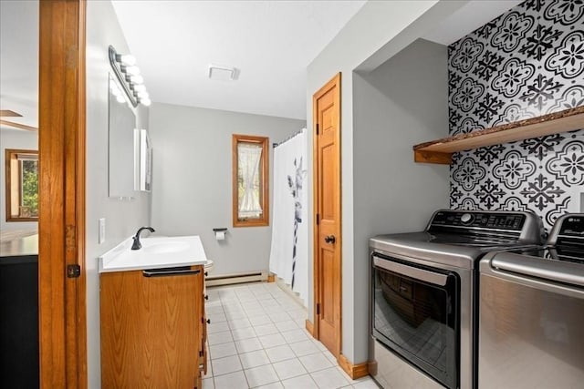 laundry room featuring washing machine and dryer, a baseboard radiator, light tile patterned floors, laundry area, and a sink