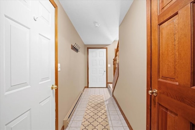 doorway featuring light tile patterned floors, baseboards, and baseboard heating