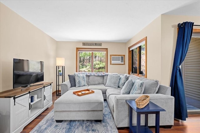 living room with dark wood-style floors and a wall unit AC