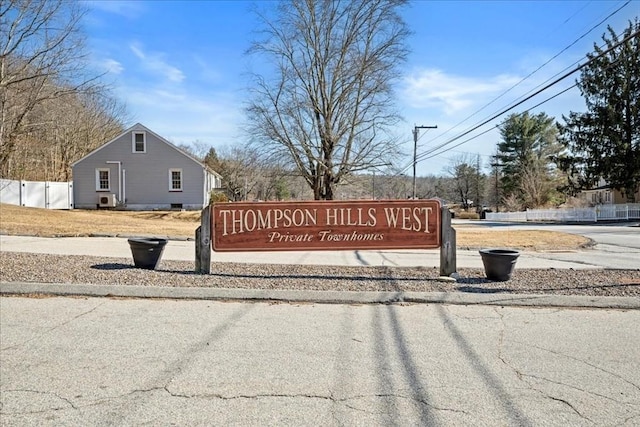 community / neighborhood sign featuring fence