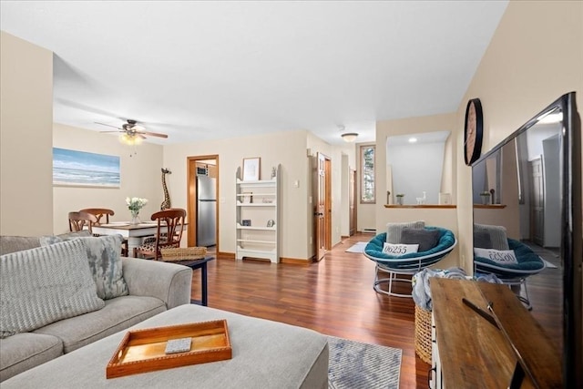 living room featuring baseboards, wood finished floors, and a ceiling fan