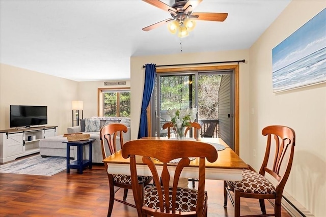 dining room with a ceiling fan, wood finished floors, and baseboard heating