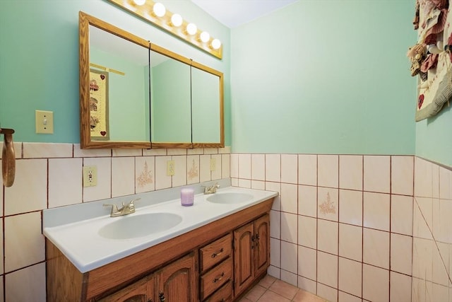 bathroom featuring double vanity, tile walls, wainscoting, and a sink
