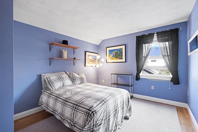 bedroom featuring wood finished floors and baseboards
