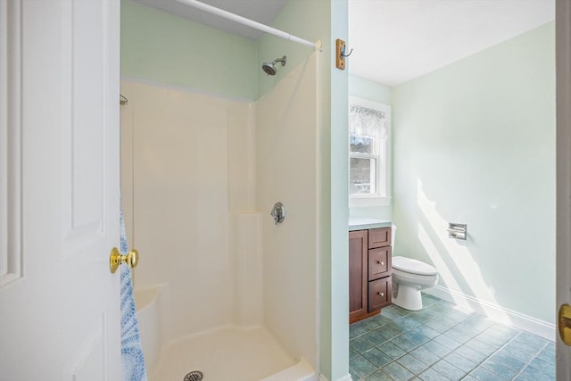 full bathroom featuring vanity, baseboards, a shower stall, and toilet