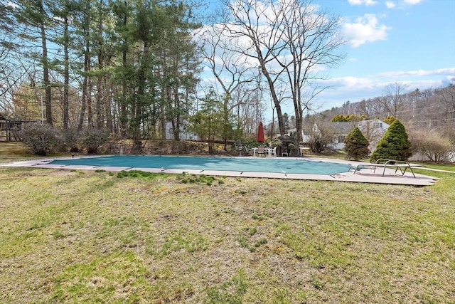 view of swimming pool with a lawn and a covered pool
