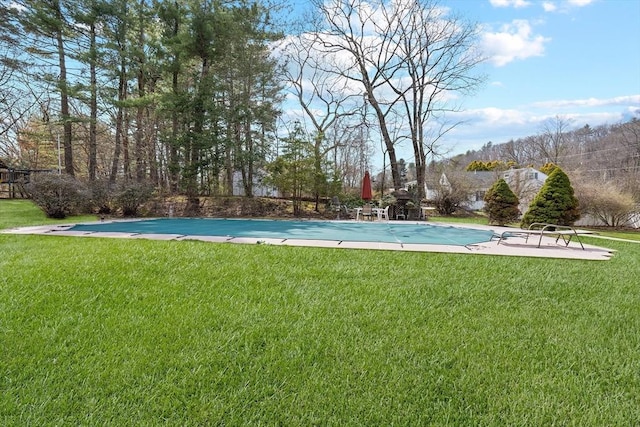 view of swimming pool with a covered pool and a yard