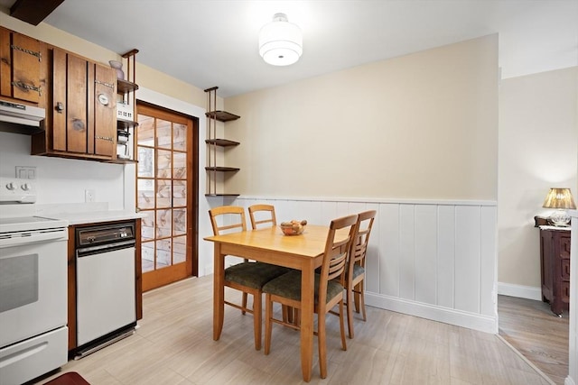 dining room featuring a wainscoted wall and light wood-style flooring