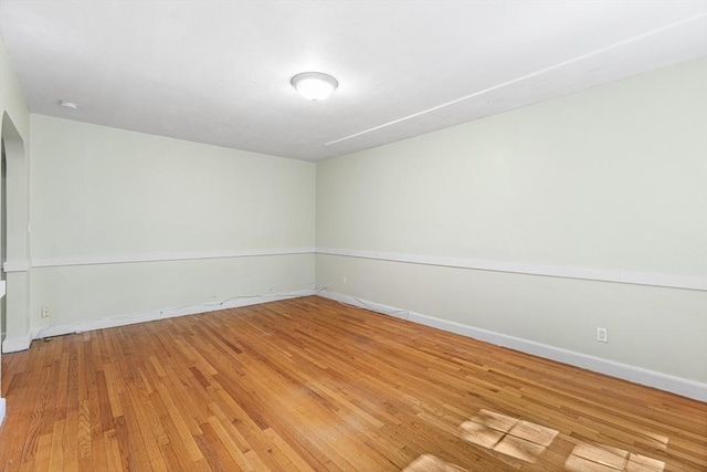 empty room featuring baseboards and light wood-type flooring