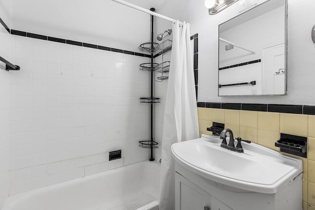 bathroom featuring shower / bath combo with shower curtain, visible vents, and vanity