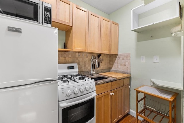 kitchen with open shelves, decorative backsplash, white appliances, a sink, and light wood-style flooring