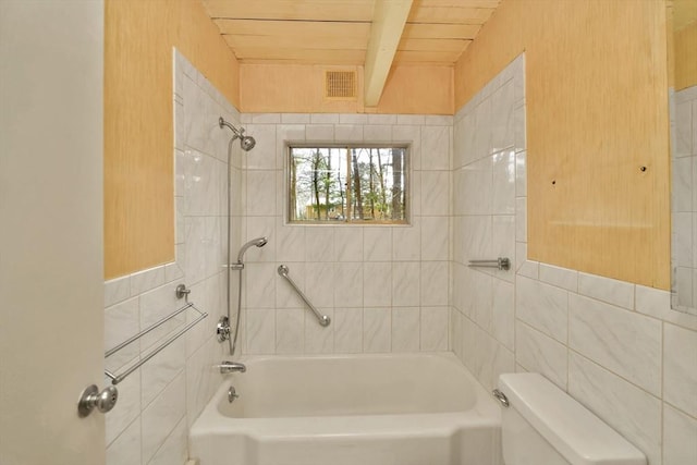 full bathroom with visible vents, toilet, tile walls, beam ceiling, and bathing tub / shower combination