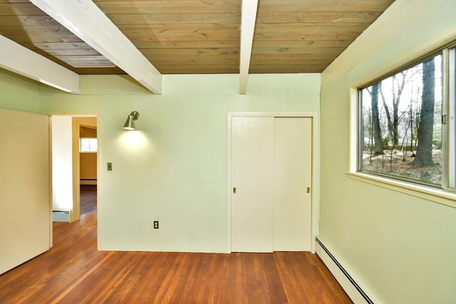 empty room with a baseboard heating unit, wooden ceiling, beam ceiling, and wood finished floors