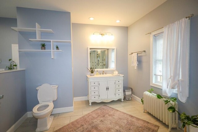 bathroom featuring vanity, tile patterned flooring, radiator heating unit, and toilet