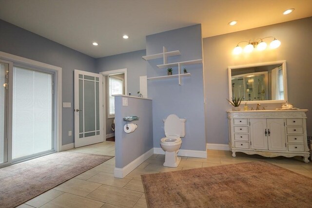 full bathroom featuring a stall shower, vanity, baseboards, toilet, and recessed lighting