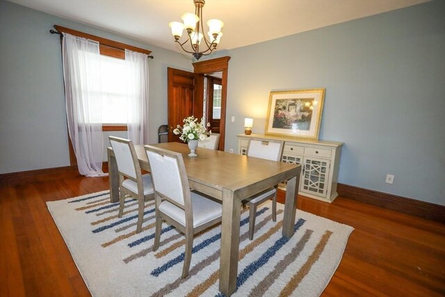 dining room featuring baseboards, wood finished floors, and a chandelier