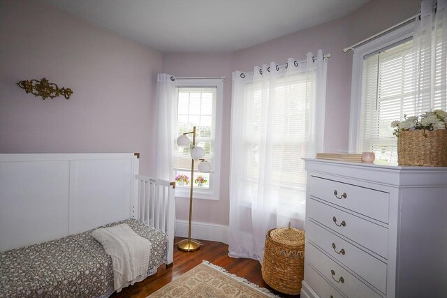 bedroom with baseboards and dark wood-style floors