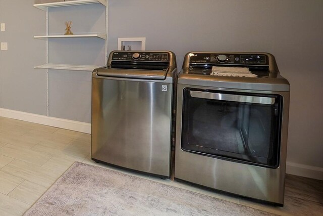 laundry room featuring baseboards, washer and clothes dryer, and laundry area