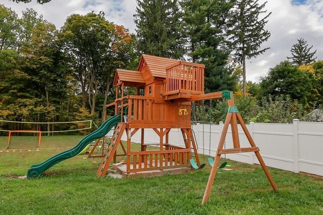 view of playground featuring a lawn and fence