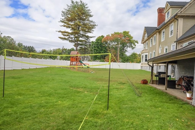view of yard featuring a playground, a fenced backyard, and a patio area