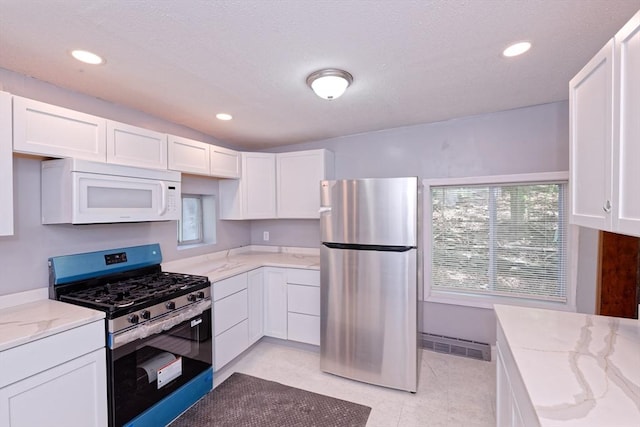 kitchen with stainless steel appliances, white cabinetry, light stone countertops, plenty of natural light, and recessed lighting