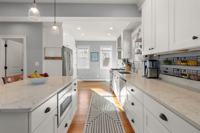 kitchen with light wood-type flooring, recessed lighting, stainless steel appliances, white cabinetry, and a baseboard radiator