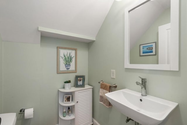 bathroom featuring lofted ceiling and a sink