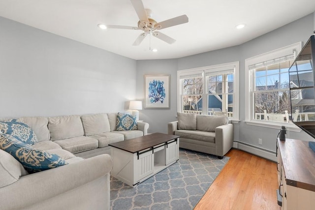 living room featuring light wood finished floors, recessed lighting, a baseboard heating unit, and ceiling fan