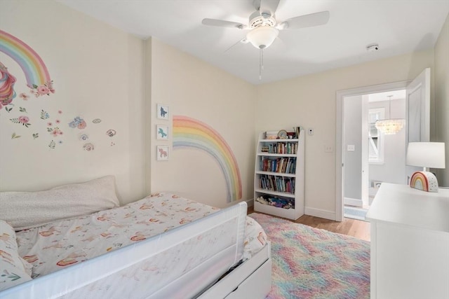 bedroom with light wood-style flooring, baseboards, and ceiling fan