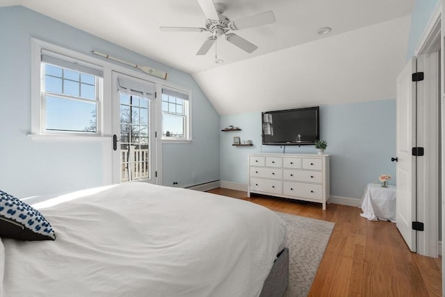 bedroom with baseboards, a baseboard radiator, lofted ceiling, wood finished floors, and access to outside