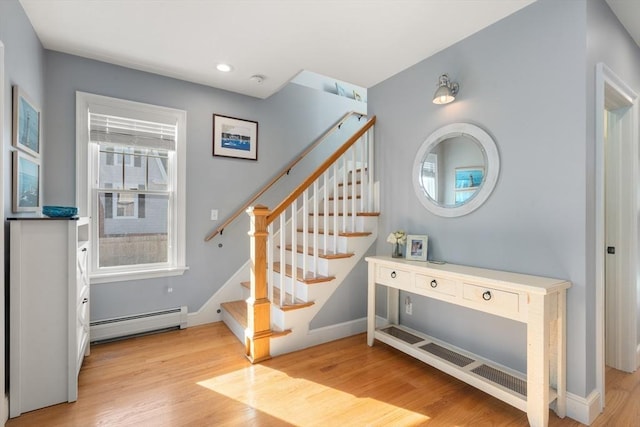 staircase featuring recessed lighting, a baseboard radiator, baseboards, and wood finished floors