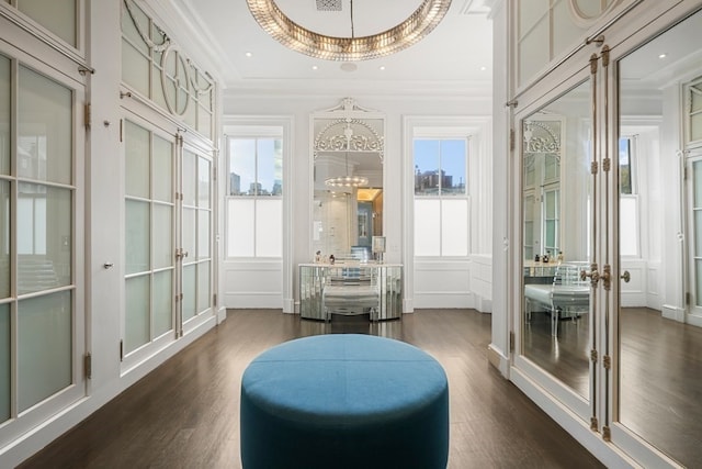 living area with a chandelier, crown molding, french doors, and dark hardwood / wood-style flooring