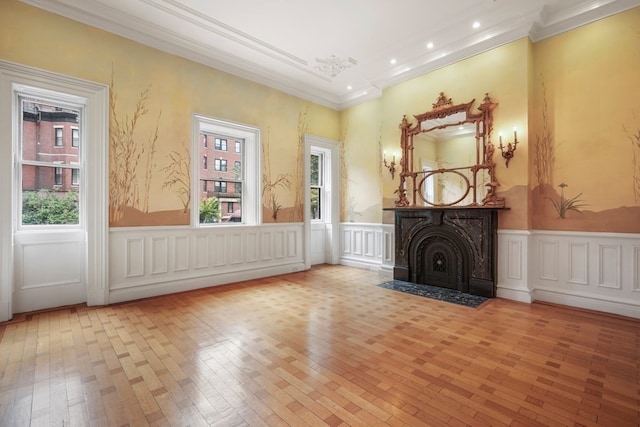 unfurnished living room featuring light hardwood / wood-style flooring, ornamental molding, and a healthy amount of sunlight