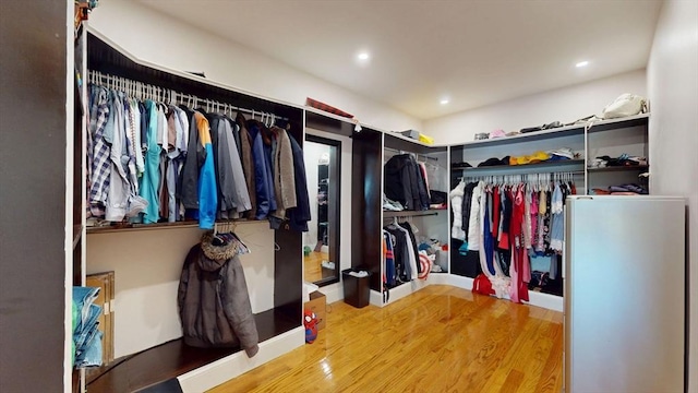 walk in closet with wood finished floors