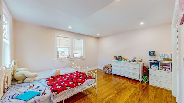 bedroom with wood finished floors, recessed lighting, and baseboards