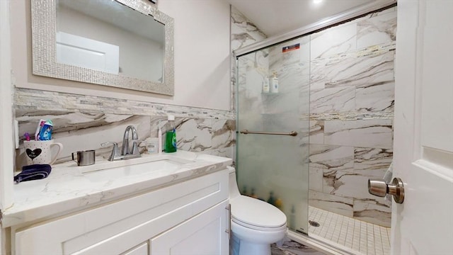 bathroom featuring a marble finish shower, toilet, tile walls, and vanity