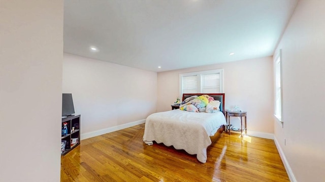 bedroom with wood finished floors, baseboards, and recessed lighting