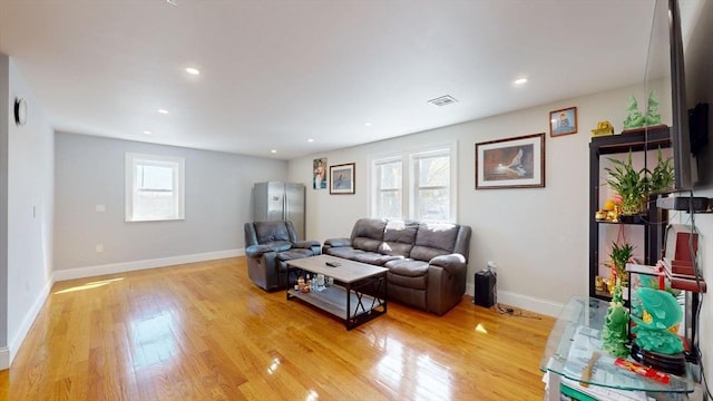 living room with light wood finished floors, baseboards, and recessed lighting