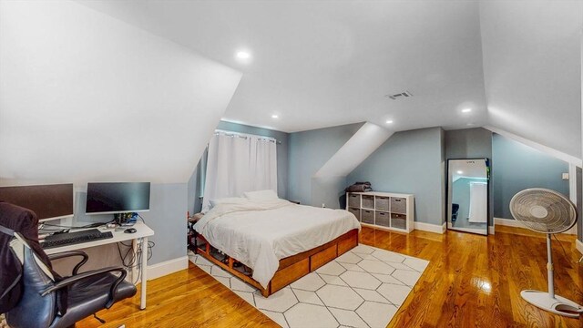 bedroom with wood finished floors, vaulted ceiling, baseboards, and recessed lighting