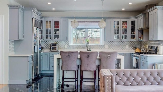 kitchen featuring stainless steel appliances, gray cabinets, backsplash, recessed lighting, and glass insert cabinets