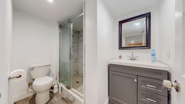 full bathroom featuring a stall shower, toilet, baseboards, and vanity