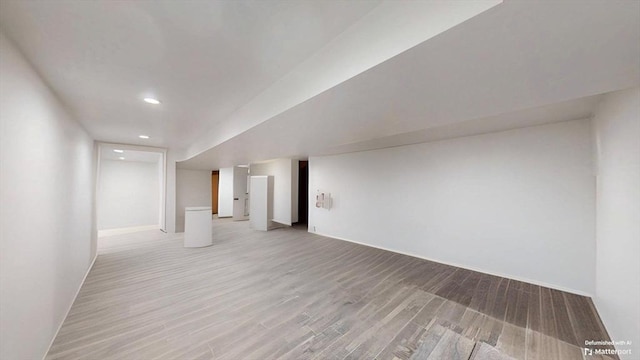 finished below grade area featuring light wood finished floors and recessed lighting