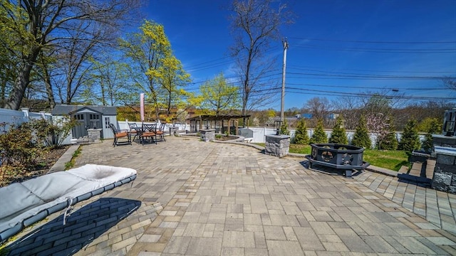 view of patio / terrace featuring a shed, an outdoor structure, outdoor dining area, and a fenced backyard