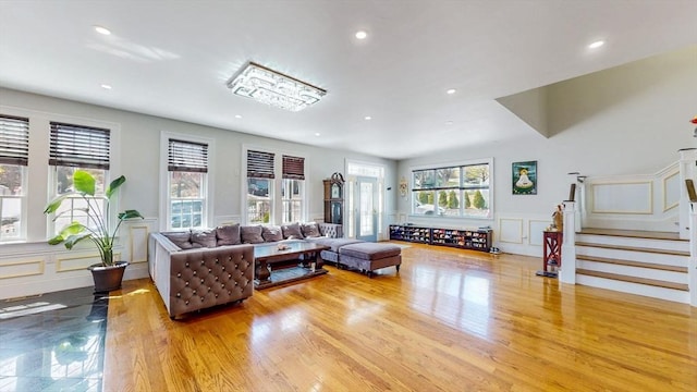 living room featuring a decorative wall, healthy amount of natural light, recessed lighting, stairway, and a wainscoted wall