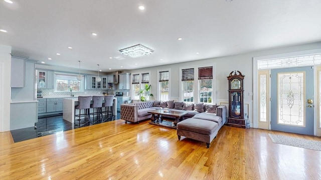 living room featuring wood finished floors, recessed lighting, and a wainscoted wall