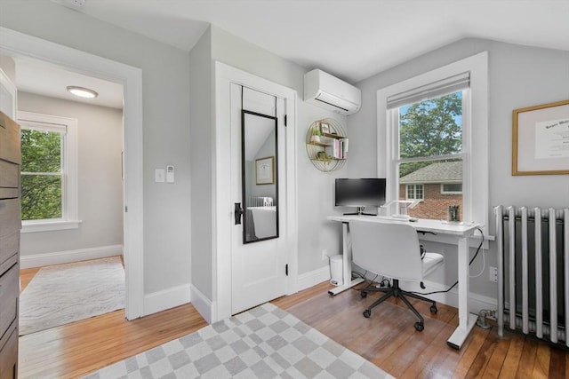 475 E St, Dedham, MA 02026 - home office featuring radiator, a wall mounted AC, wood finished floors, baseboards, and lofted ceiling