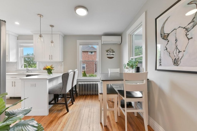 475 E St, Dedham, MA 02026 - dining area featuring radiator heating unit, a wall unit AC, light wood-style floors, baseboards, and recessed lighting