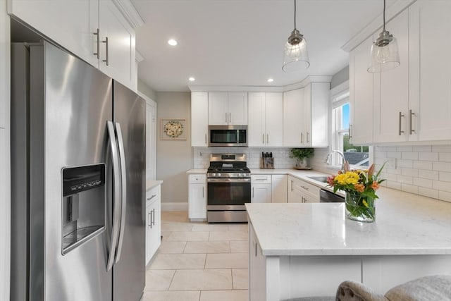 475 E St, Dedham, MA 02026 - kitchen with stainless steel appliances, a sink, a peninsula, decorative backsplash, and light stone countertops